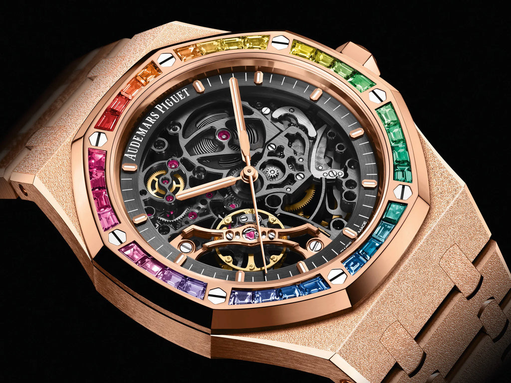 Audemars Piguet Royal Oak Double Balance Wheel Open-worked features a frosted rose gold finish and a bezel set with rainbow-colored baguette-cut sapphires