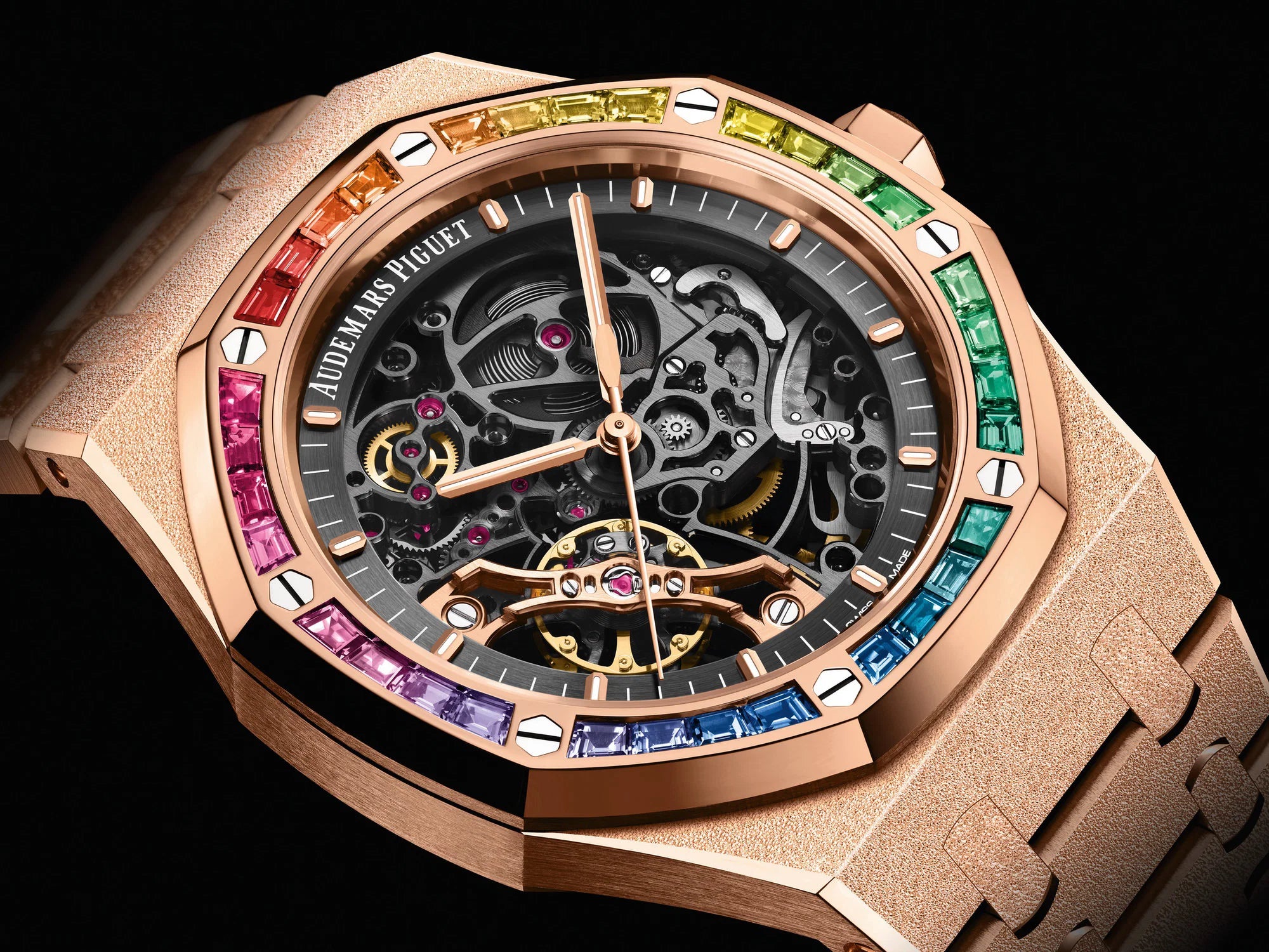 Audemars Piguet Royal Oak Double Balance Wheel Open-worked features a frosted rose gold finish and a bezel set with rainbow-colored baguette-cut sapphires