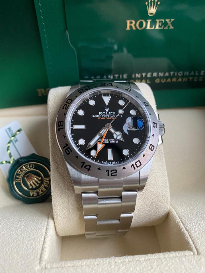 Rolex Explorer II, featuring a black dial, fixed steel bezel, and a distinctive orange GMT hand