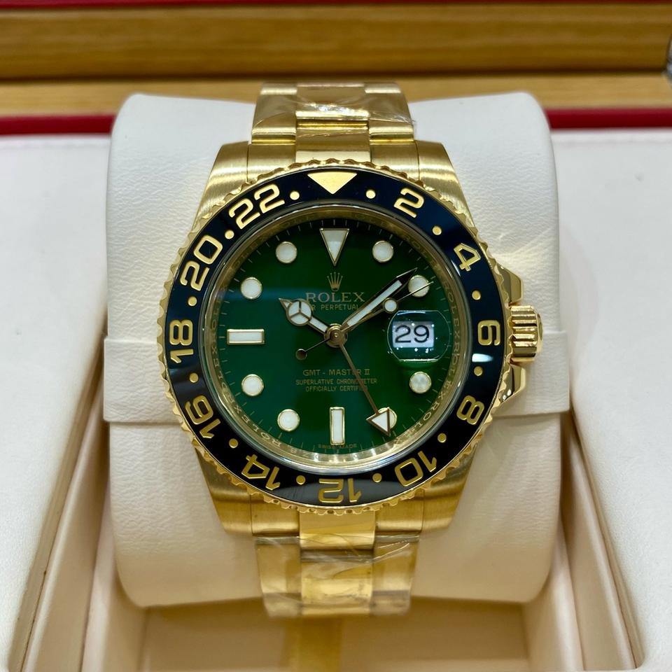Rolex GMT-Master II Yellow Gold watch featuring a distinct green dial and a black ceramic bezel