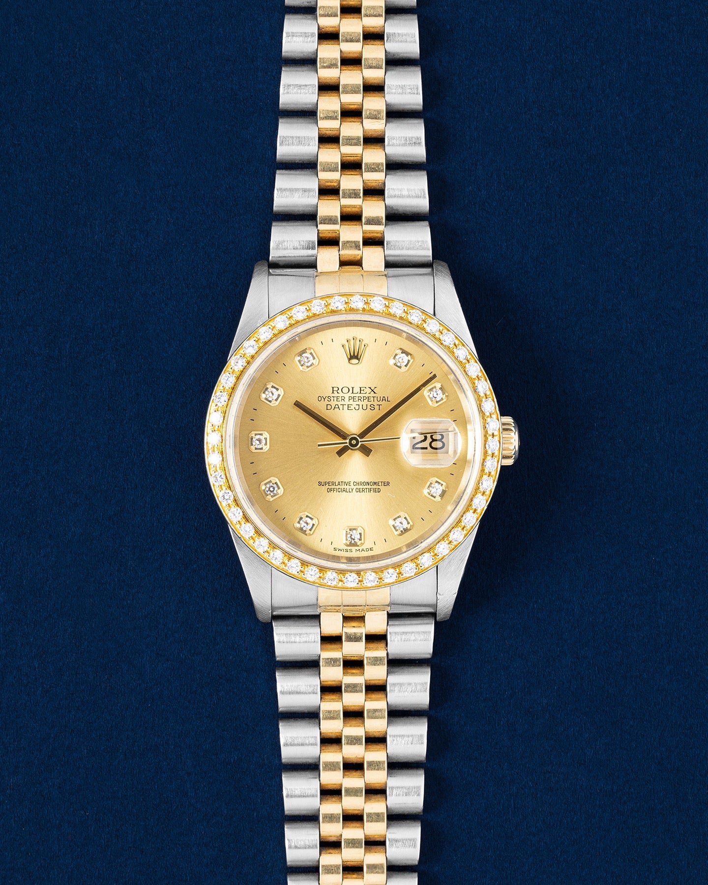 Rolex Datejust 16233 features a 36mm stainless steel case with an yellow gold bezel set with diamonds and a champagne diamond dial