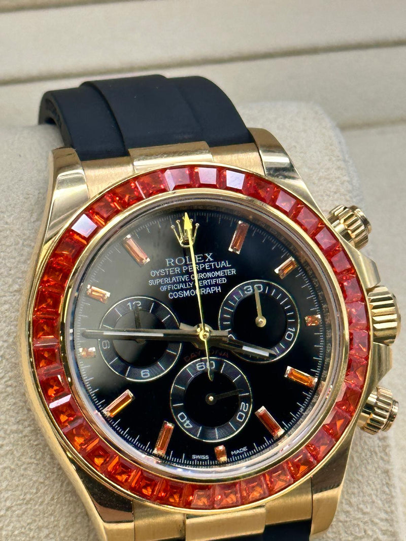 Rolex Cosmograph Daytona features yellow gold case and a bezel set with baguette-cut orange sapphires