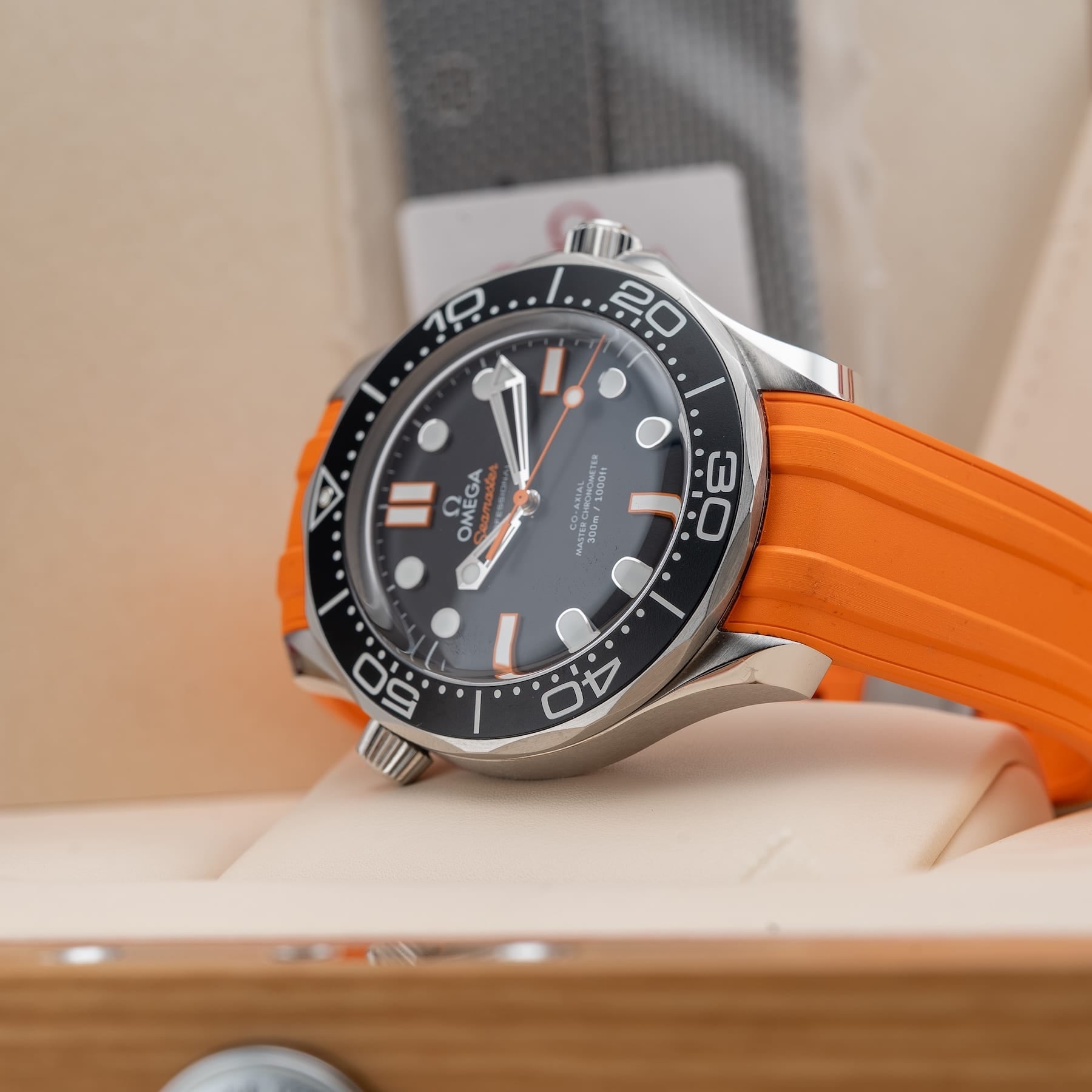 Omega Seamaster Diver 300M features a striking black matte dial paired with a vibrant orange rubber strap