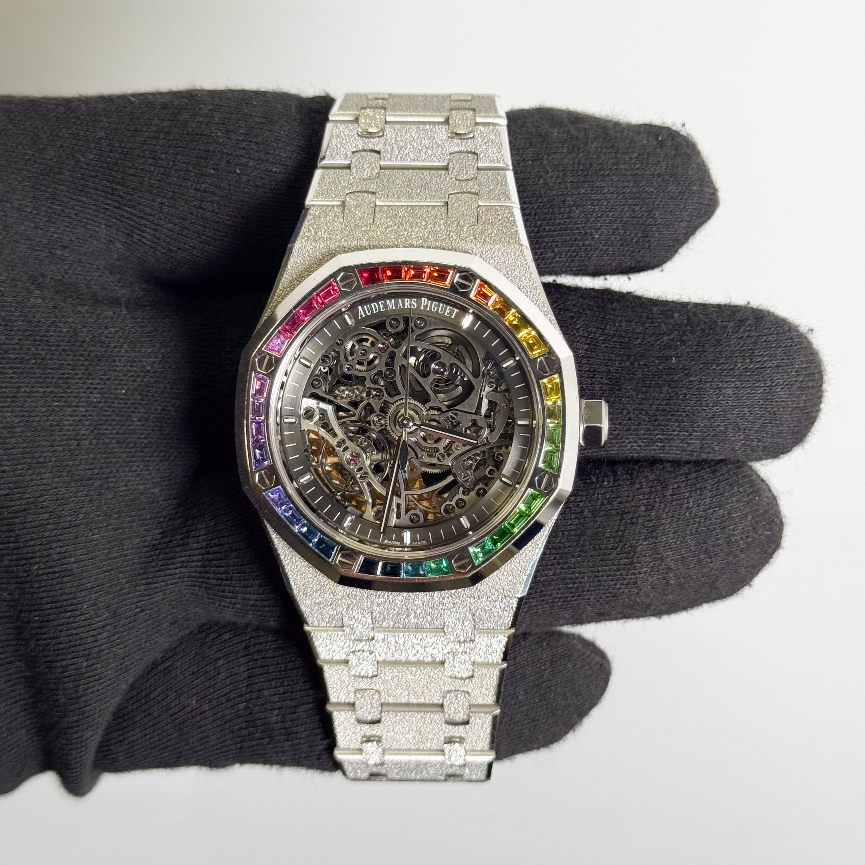 Audemars Piguet Royal Oak Double Balance Wheel Open-worked features a frosted white gold finish and a bezel set with rainbow-colored baguette-cut sapphires