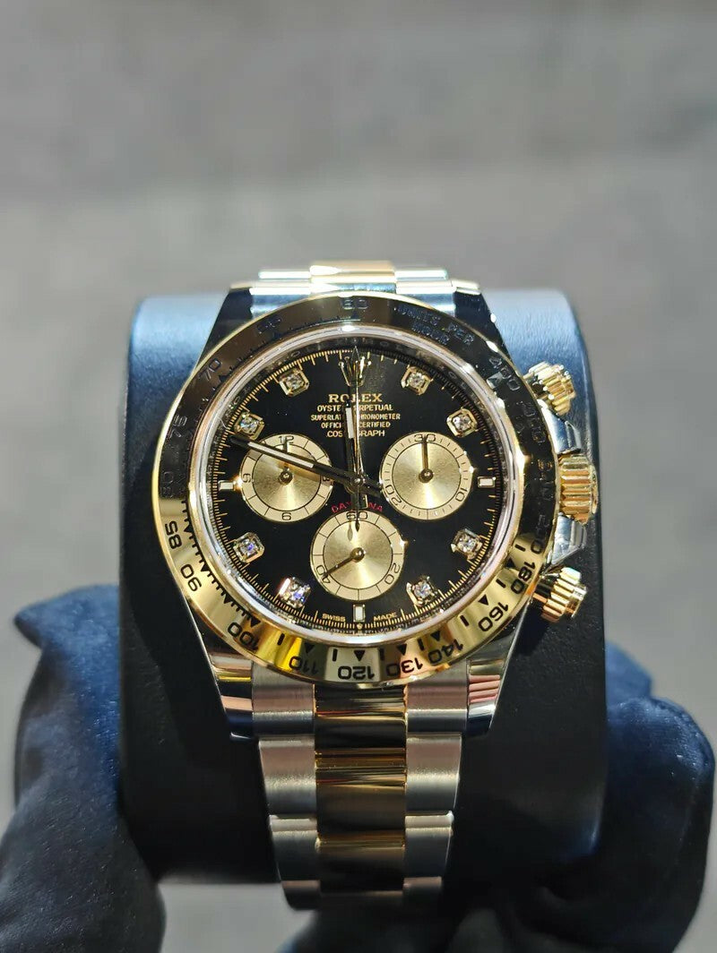 Rolex Cosmograph Daytona watch features a two-tone Oystersteel and yellow gold case with a striking black diamond dial