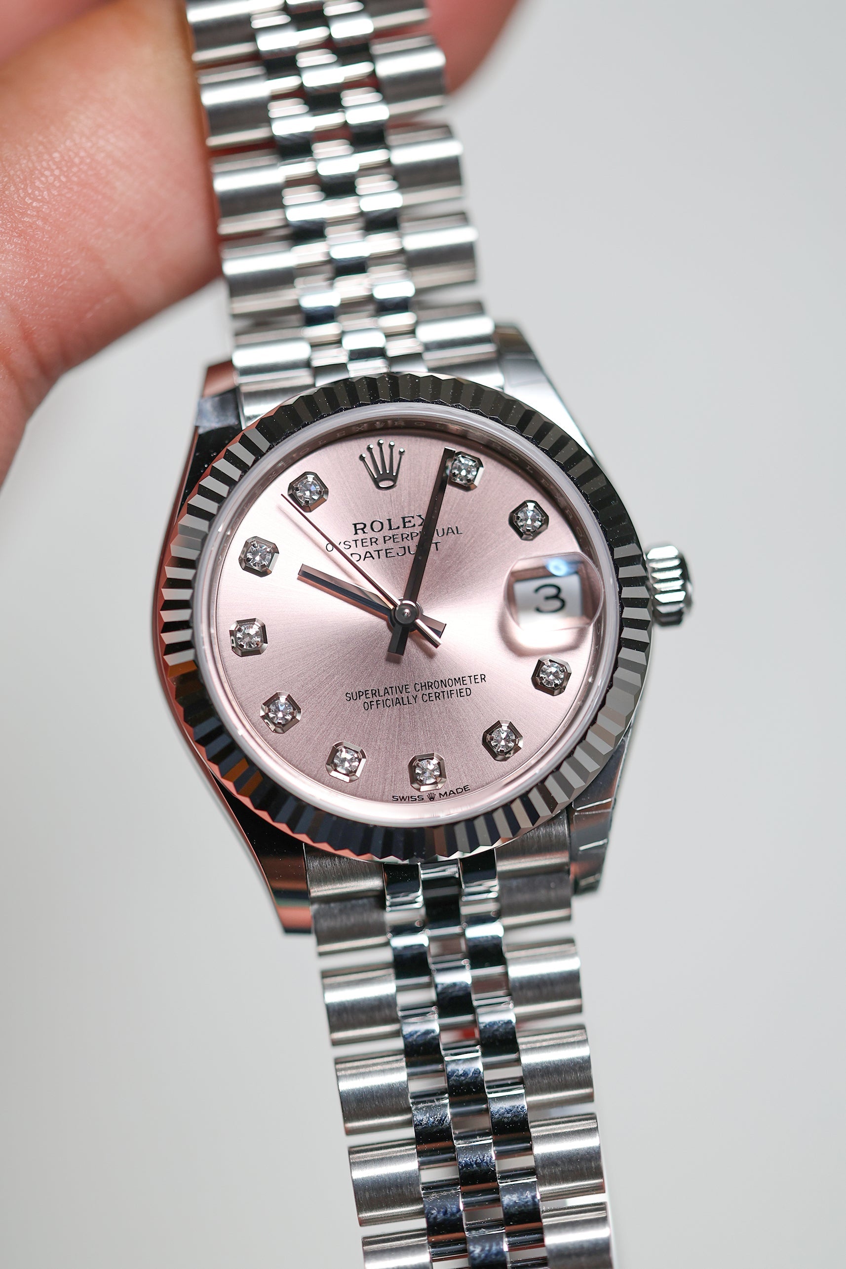Rolex Datejust 31 features a pink dial with diamond hour markers and a fluted white gold bezel